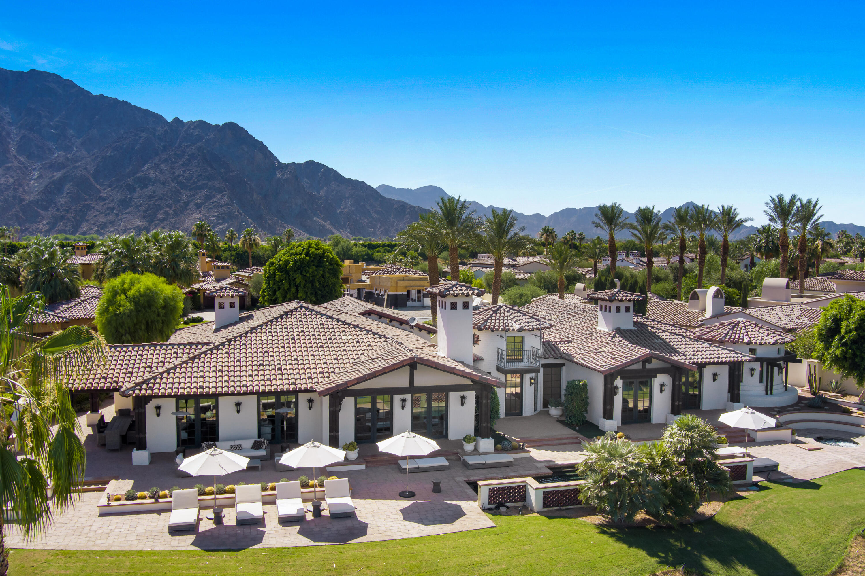 a front view of a house with a garden and lake view