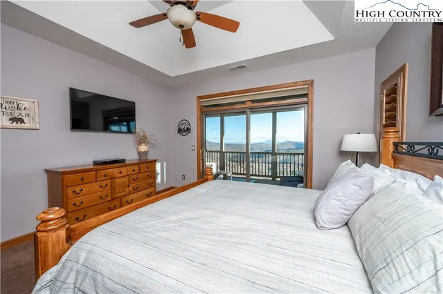 a bedroom with a bed and a flat tv screen on dresser