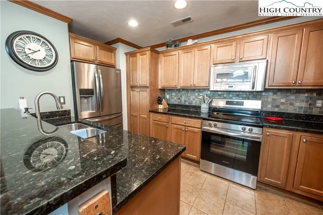 a kitchen with kitchen island granite countertop a stove a sink and a refrigerator