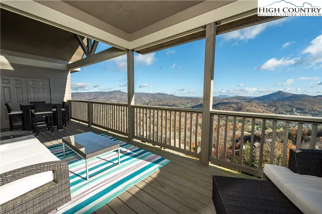 a balcony with wooden floor table and chairs