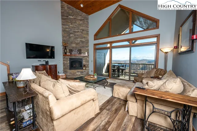 a living room with furniture a flat screen tv and a large window