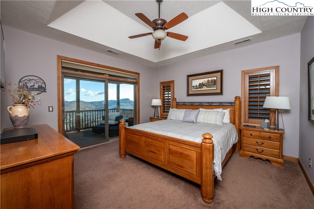 342 Ridgeline Drive, Unit 15B Sugar Mountain, NC 28604 - Photo 10 of 26 a bedroom with a bed and a chandelier