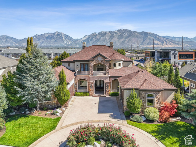 11353 Portabello Road South Jordan, UT 84095 - Photo 1 of 1 Mediterranean / spanish house featuring driveway, stone siding, a mountain view, a balcony, and a chimney