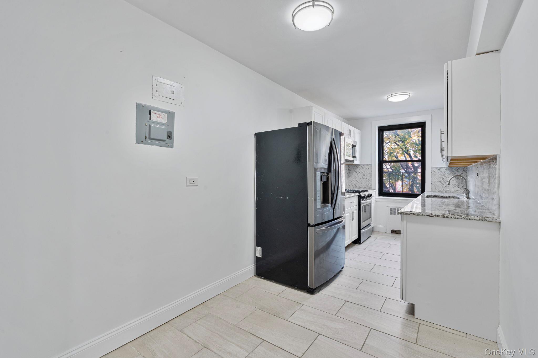 32-40 89th Street, Unit C409 Queens, NY 11369 - Photo 20 of 32 a kitchen with stainless steel appliances a refrigerator and a stove