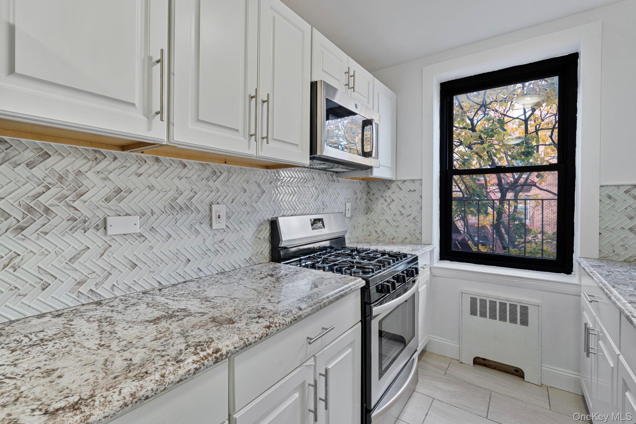 32-40 89th Street, Unit C409 Queens, NY 11369 - Photo 23 of 32 a stove top oven sitting inside of a kitchen