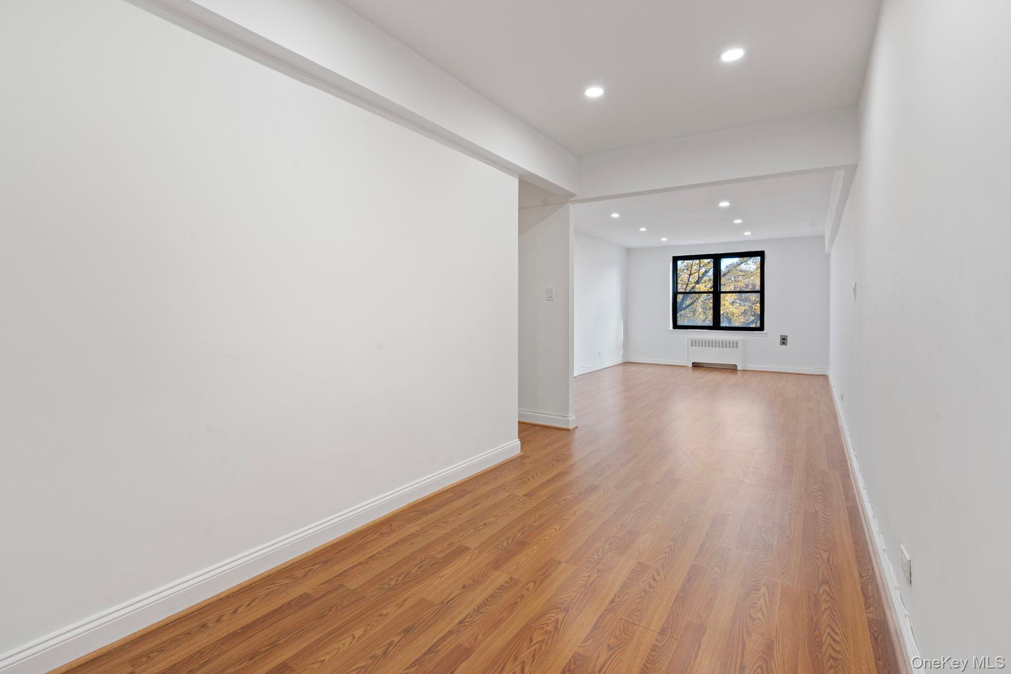 32-40 89th Street, Unit C409 Queens, NY 11369 - Photo 5 of 32 wooden floor in an empty room with a window