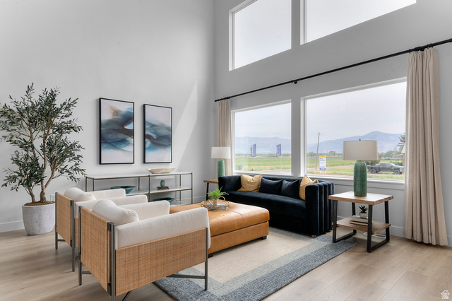 1418 West 2350th South, Unit 15 Perry, UT 84302 - Photo 5 of 22 Living area featuring high ceilings, large picture windows, wood-finish flooring, and a contemporary wall console