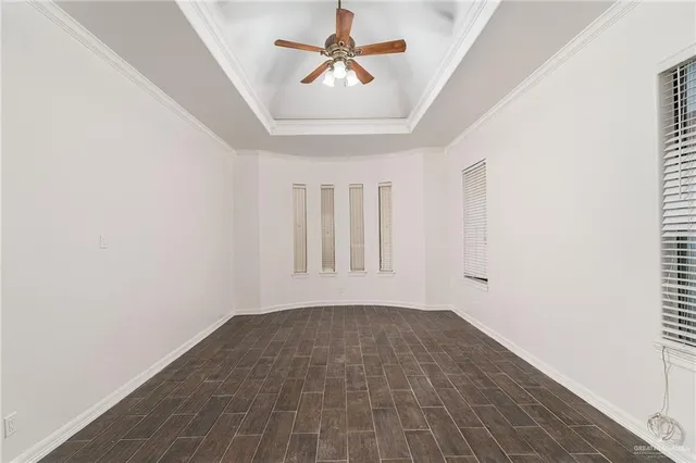 an empty room with fan and windows