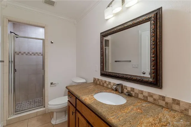 a bathroom with a granite countertop toilet a sink and a mirror