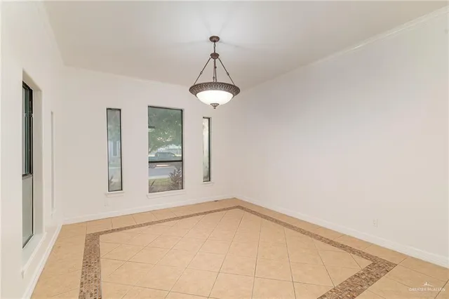a view of an empty room with chandelier and a window