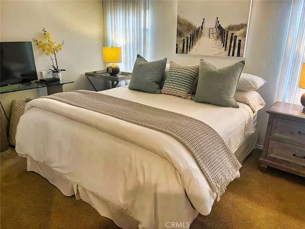 a bed sitting in a bedroom next to a window