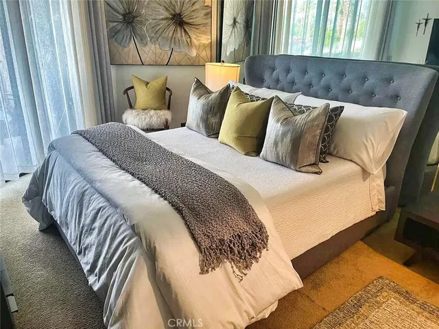 a bed sitting in a bedroom next to a window