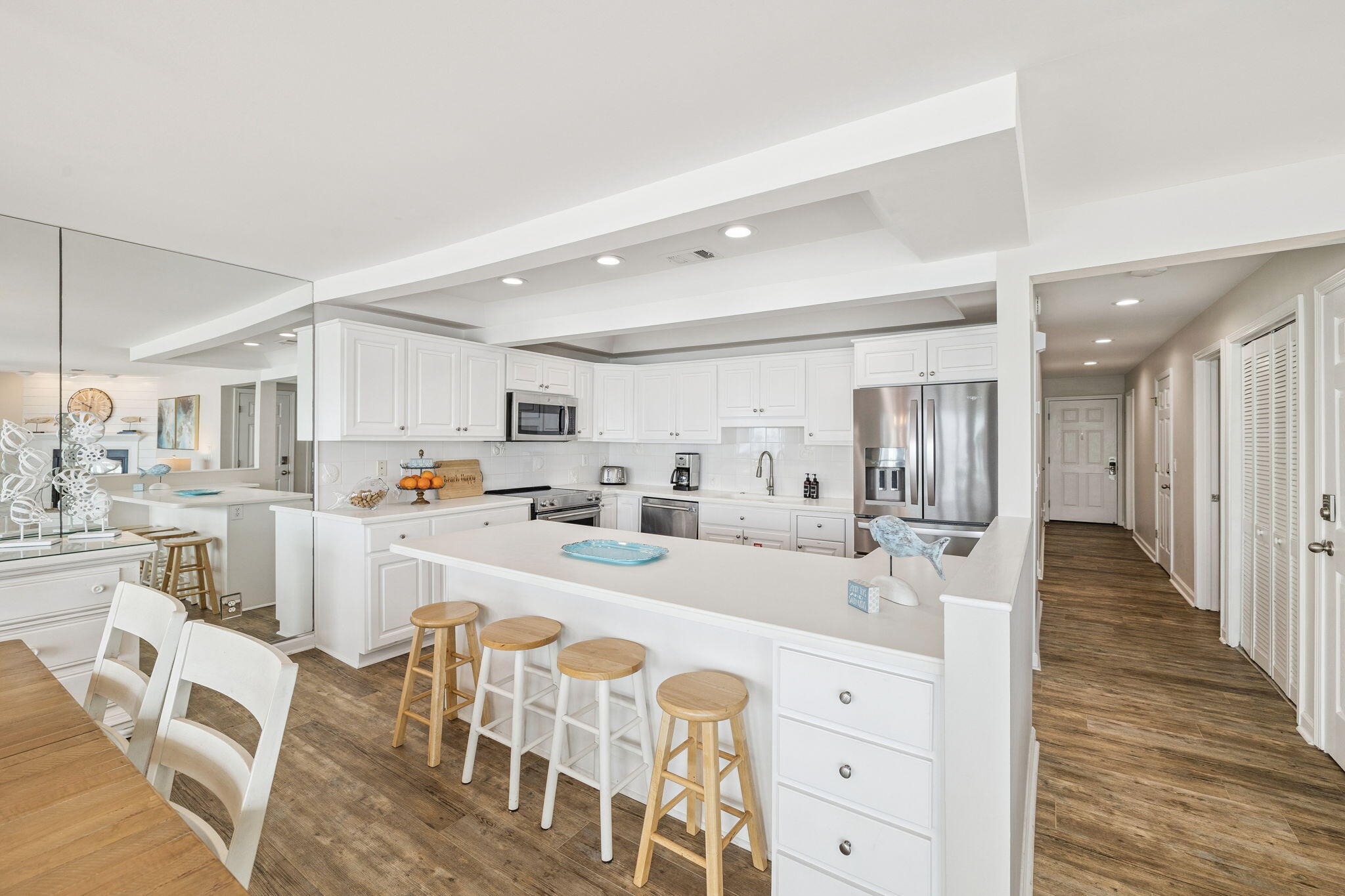 142 Beachside Drive, Unit 10 Santa Rosa Beach, FL 32459 - Photo 14 of 42 a large white kitchen with kitchen island a stove a sink dishwasher and white cabinets with wooden floor
