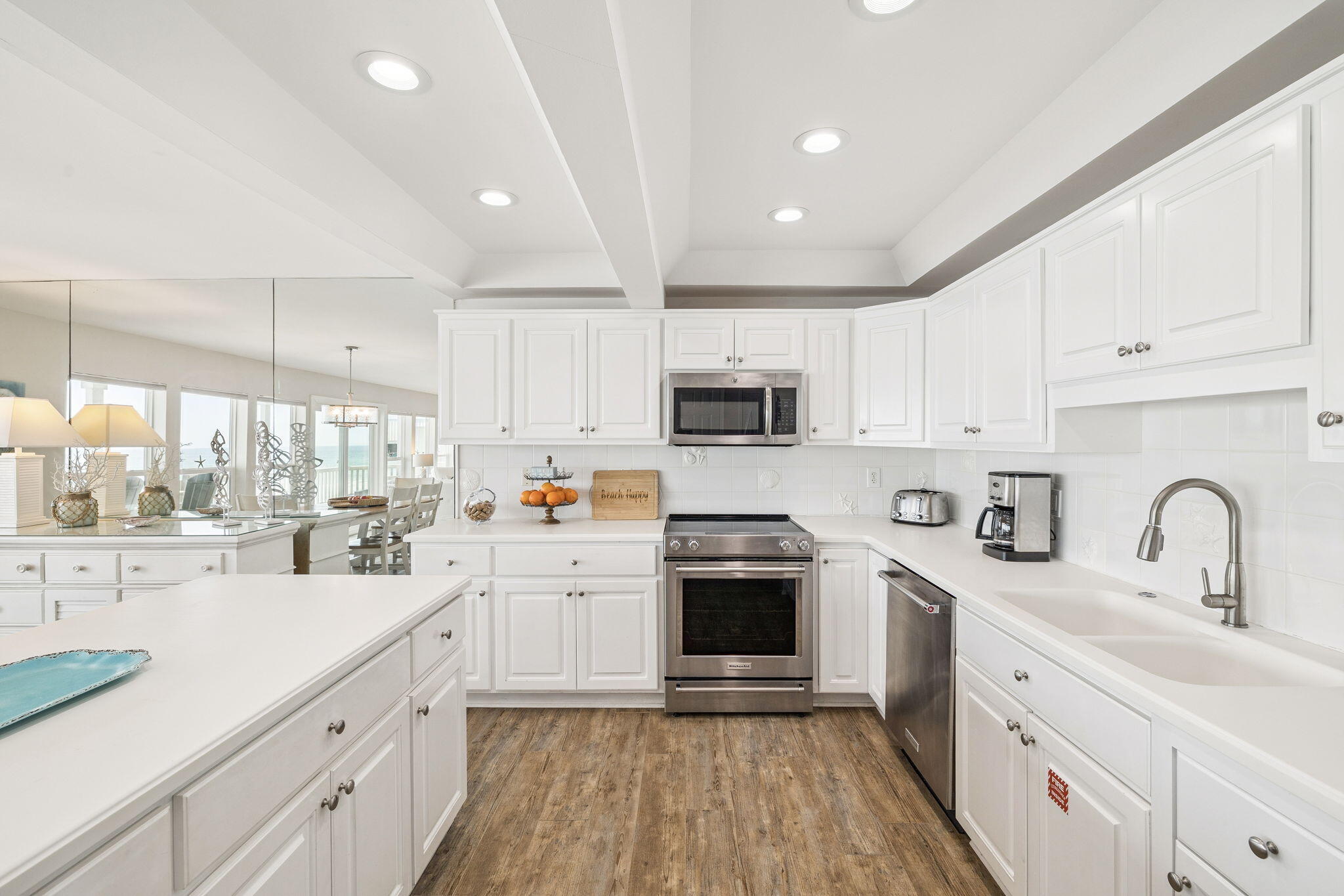 142 Beachside Drive, Unit 10 Santa Rosa Beach, FL 32459 - Photo 16 of 42 a kitchen with kitchen island granite countertop white cabinets and white appliances