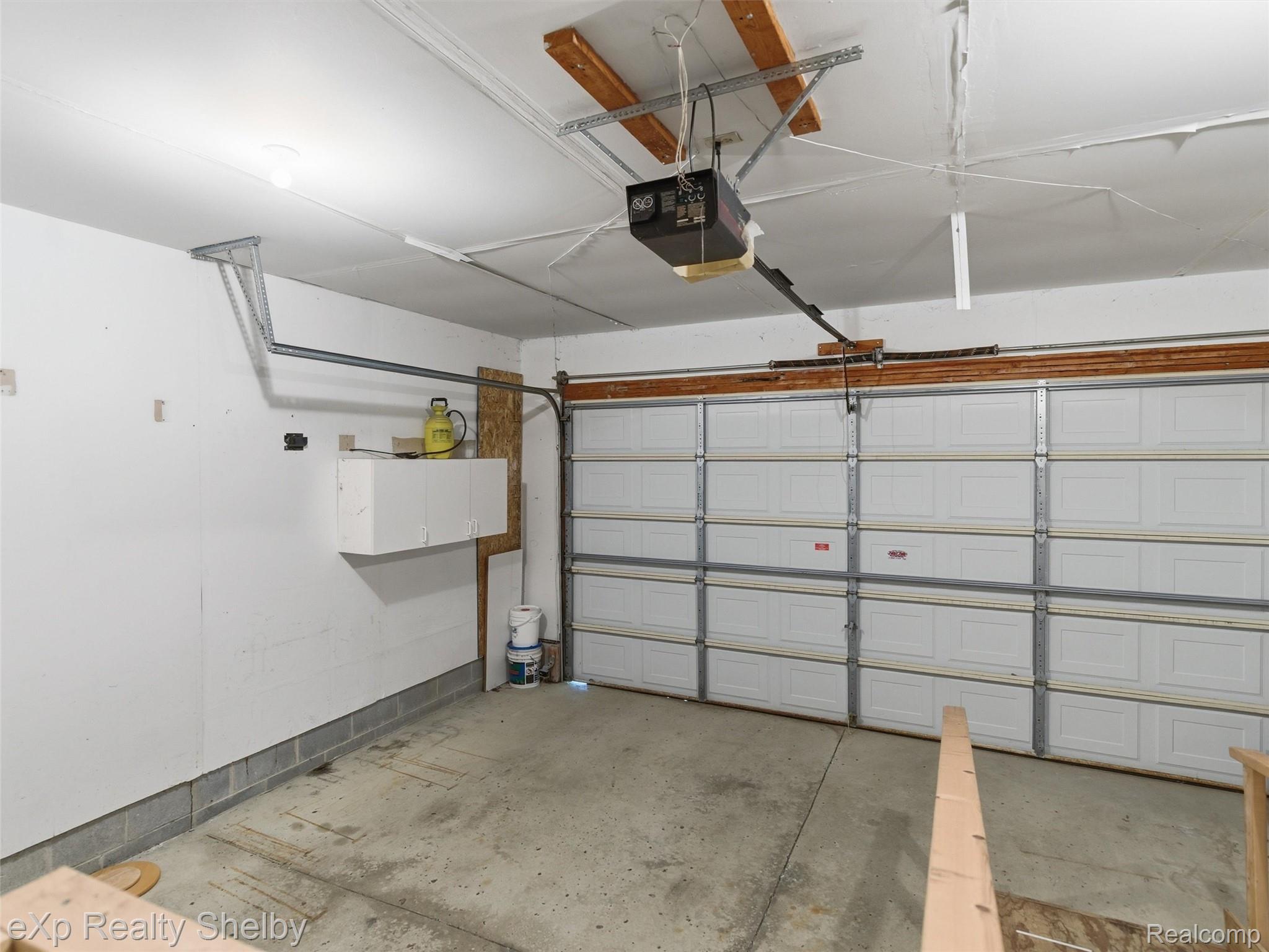 4154 Union Street Dryden, MI 48428 - Photo 31 of 41 Garage space featuring a paneled overhead door, concrete flooring, and an automatic door opener