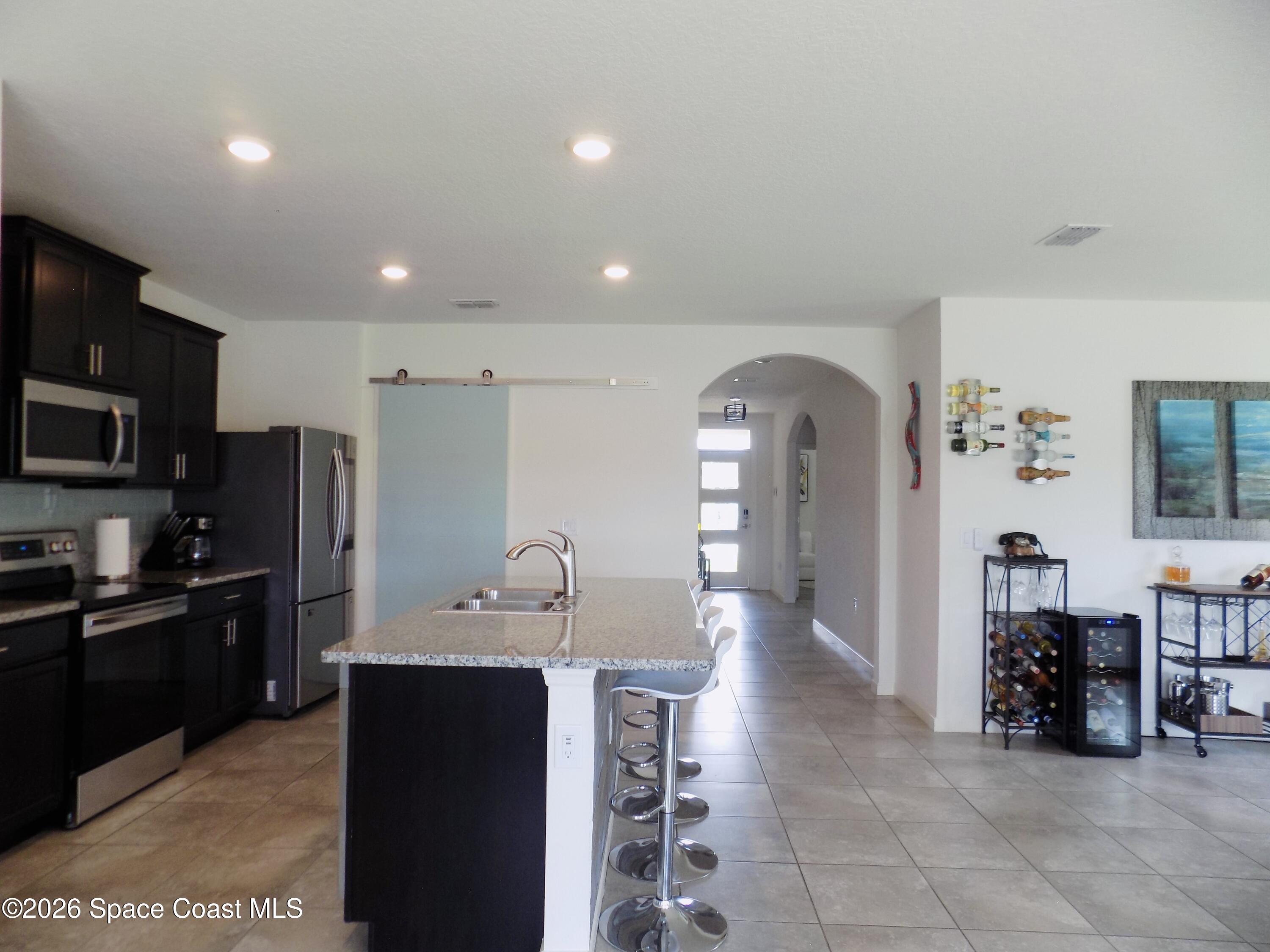 841 Old Country Rd S East Palm Bay, FL 32909 - Photo 14 of 16 a kitchen with stainless steel appliances granite countertop a refrigerator and a sink