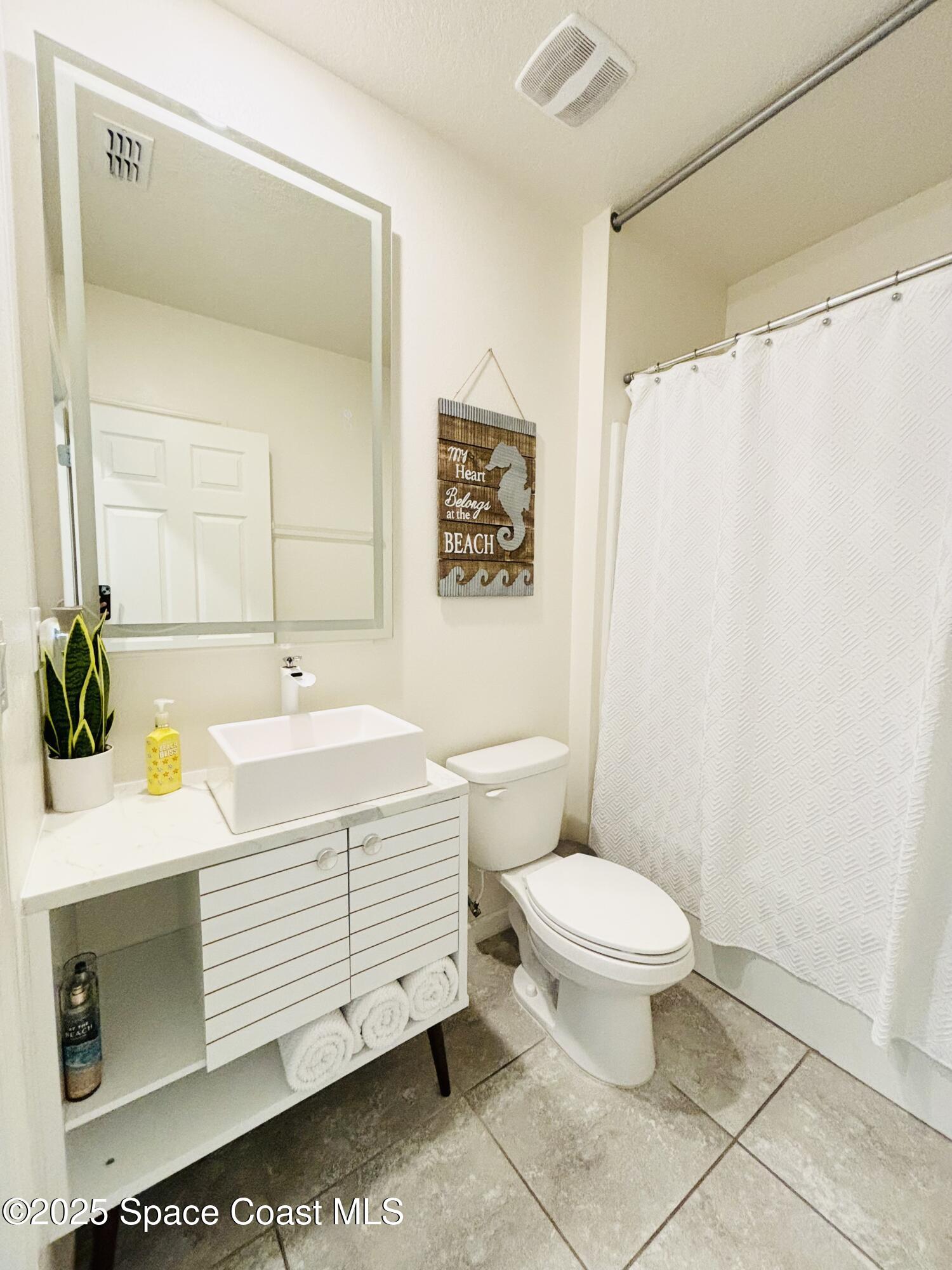 841 Old Country Rd S East Palm Bay, FL 32909 - Photo 15 of 16 a bathroom with a sink toilet and shower