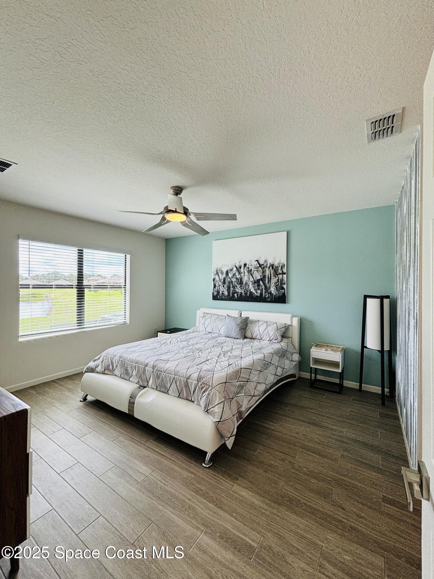 841 Old Country Rd S East Palm Bay, FL 32909 - Photo 4 of 16 a bedroom with a large bed and a window