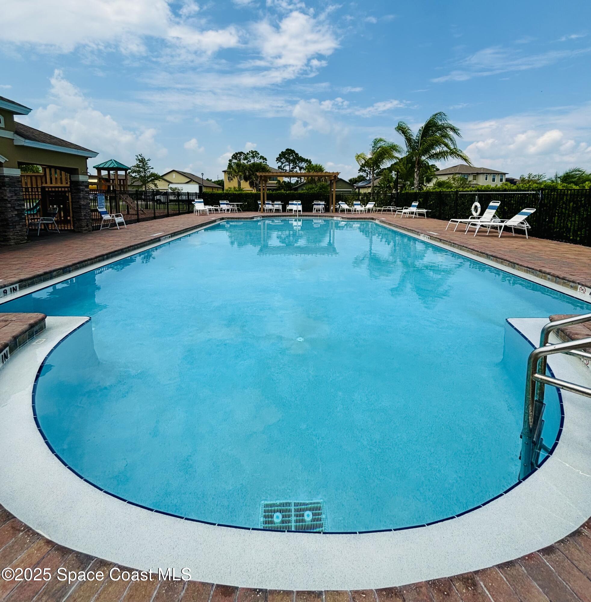 841 Old Country Rd S East Palm Bay, FL 32909 - Photo 10 of 16 a view of a swimming pool with lawn chairs and potted plants