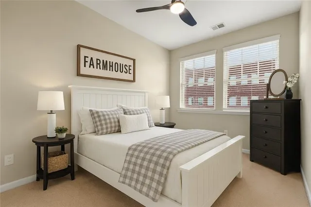 a bedroom with a bed and a dresser next to a window