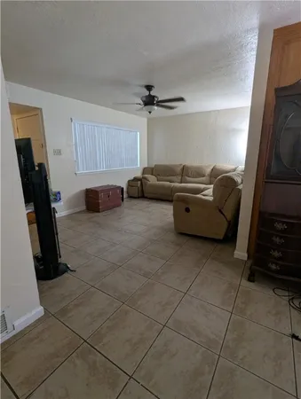 a living room with furniture a flat screen tv and a window