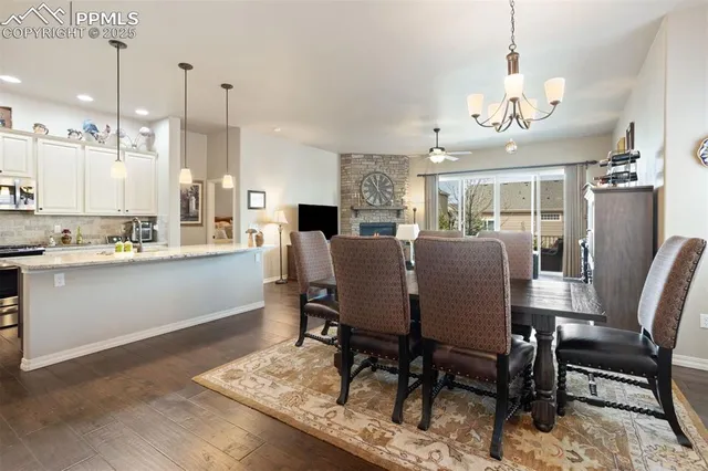 a view of a dining room and livingroom with furniture wooden floor a rug a chandelier