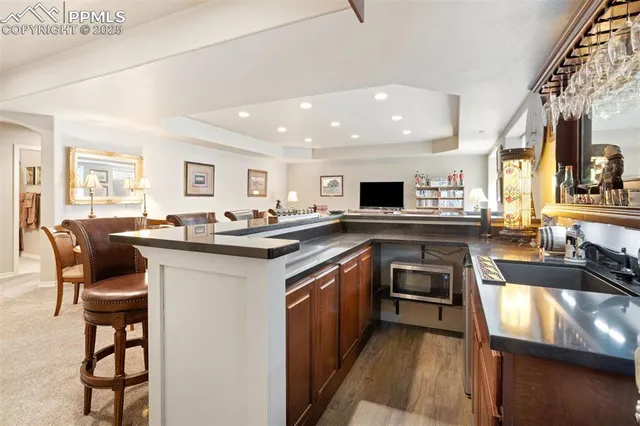 a kitchen with stainless steel appliances granite countertop a stove top oven a sink a dining table and chairs