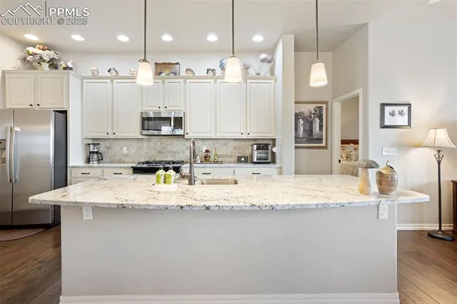 a large kitchen with stainless steel appliances kitchen island granite countertop a refrigerator a stove a sink and a granite counter tops