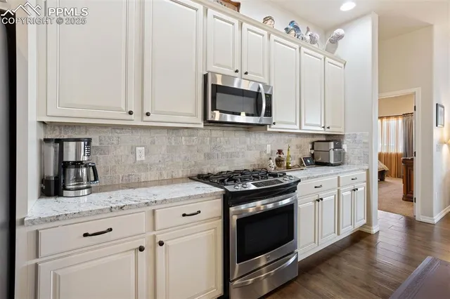 a kitchen with stainless steel appliances granite countertop a sink a stove and a microwave