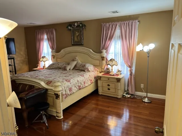 a spacious bedroom with a bed and a flat screen tv