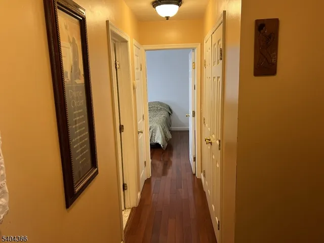 a view of a hallway with wooden floor and staircase