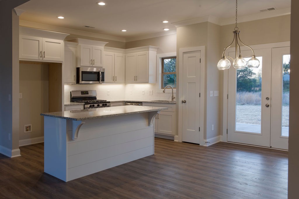2348 Allen Ferry Road Smithville, TN 37166 - Photo 7 of 23 a kitchen with kitchen island granite countertop stainless steel appliances a sink cabinets and wooden floor