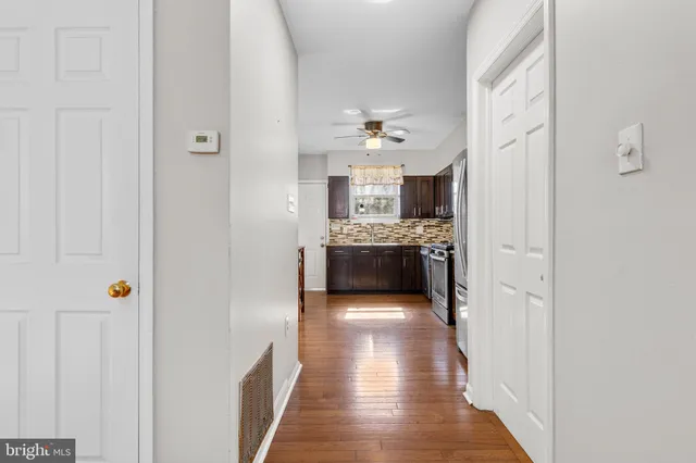 a kitchen with stainless steel appliances granite countertop a stove top oven a sink a dining table and chairs