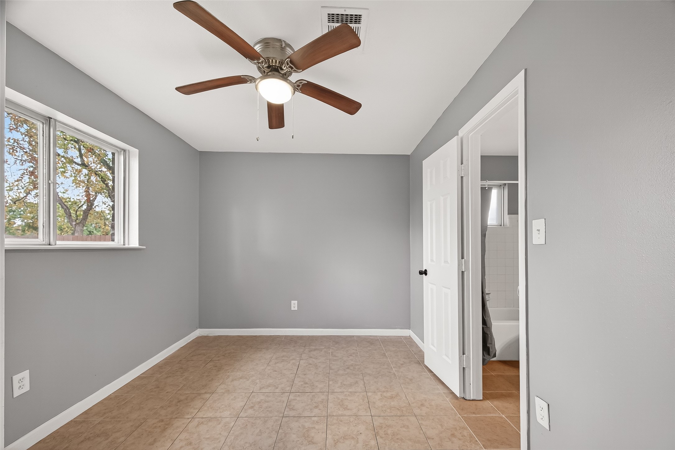 11927 Flushing Meadows Drive Houston, TX 77089 - Photo 15 of 36 an empty room with windows and fan