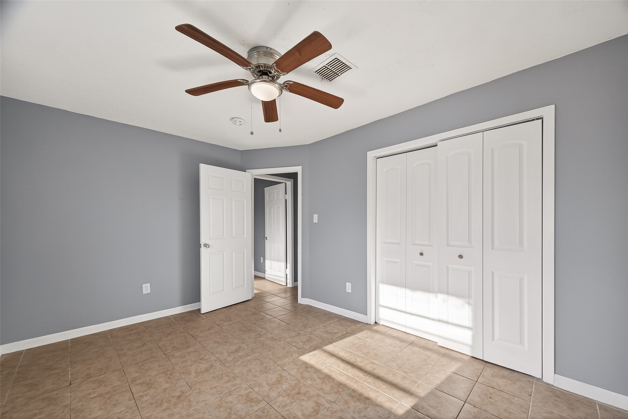 11927 Flushing Meadows Drive Houston, TX 77089 - Photo 25 of 36 an empty room with ceiling fan and windows