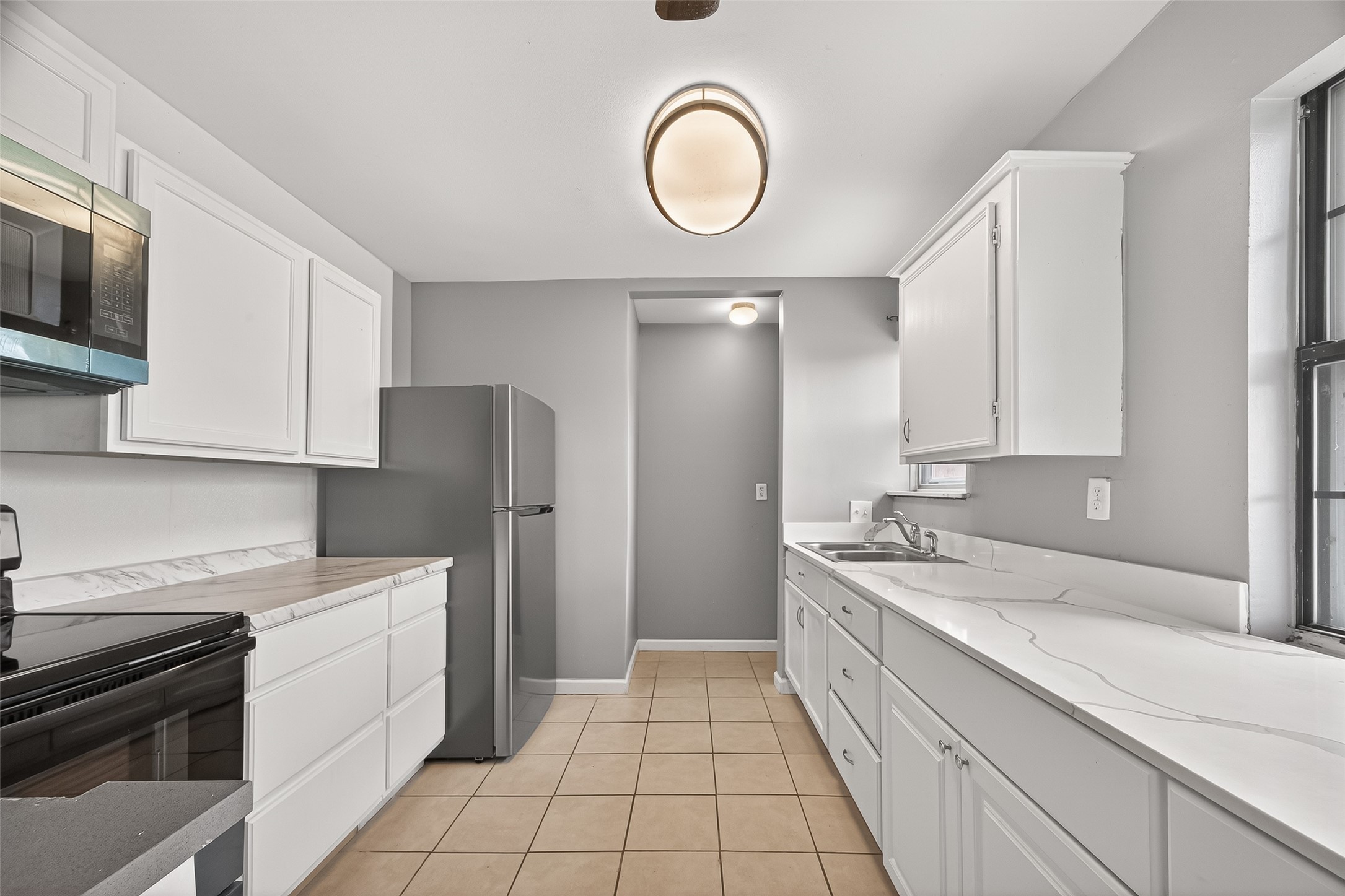 11927 Flushing Meadows Drive Houston, TX 77089 - Photo 10 of 36 a kitchen with a sink dishwasher a stove and a refrigerator with wooden floor