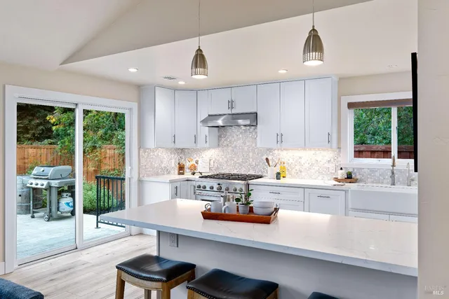 a kitchen with kitchen island a large window and cabinets