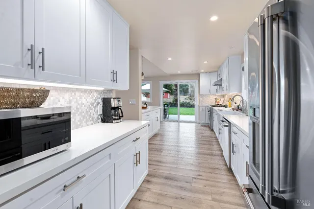 a kitchen with stainless steel appliances granite countertop a refrigerator and a stove top oven