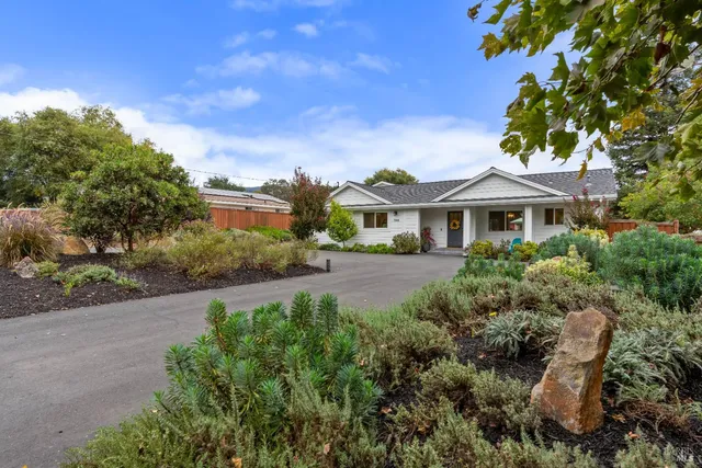 a front view of a house with a yard and potted plants