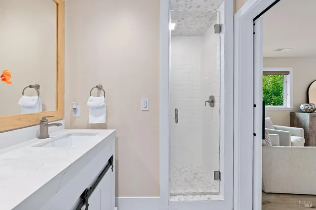 a bathroom with a double vanity sink a mirror and a shower