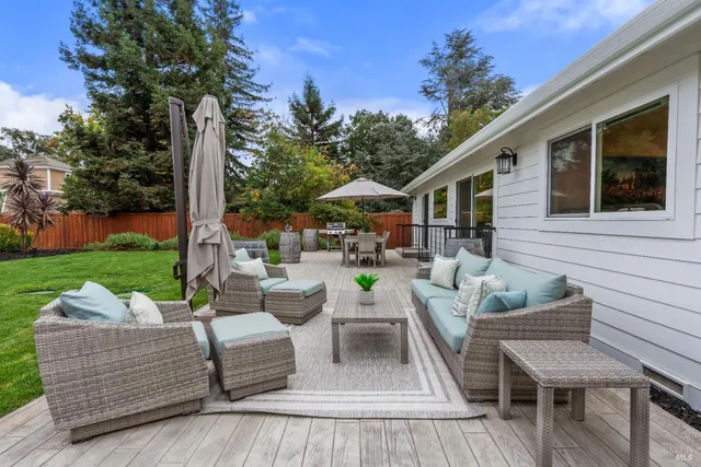 a view of a patio with couches potted plants and a big yard