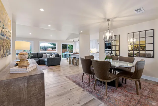 a living room with furniture dining table a window and a flat screen tv