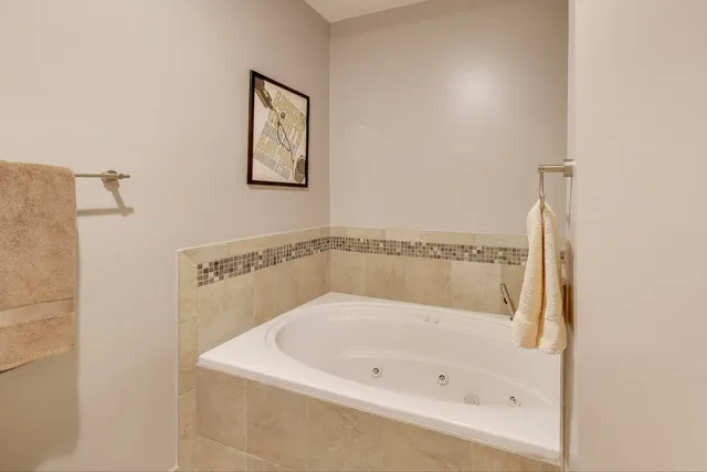 a white bath tub sitting next to a white sink and vanity