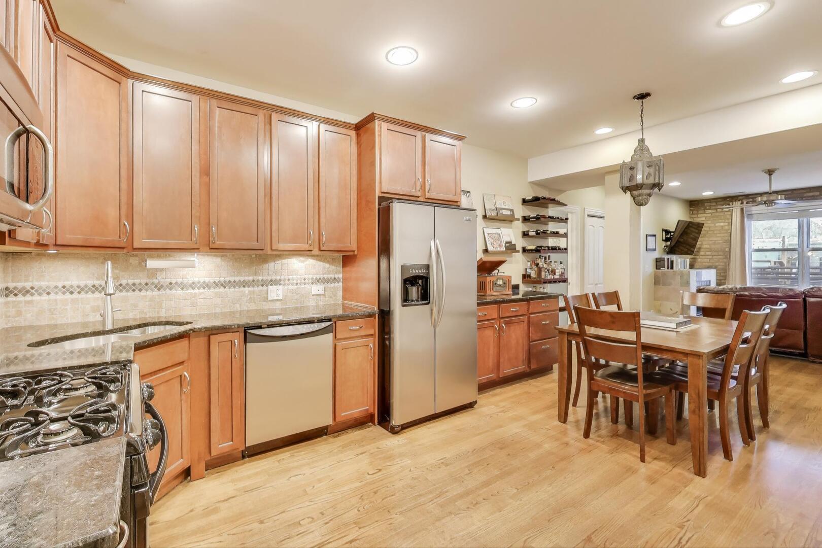 1378 North Wolcott Avenue, Unit 2C Chicago, IL 60622 - Photo 2 of 15 a kitchen with stainless steel appliances granite countertop a refrigerator a sink a stove a dining table and chairs