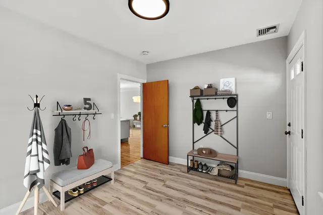 a living room with furniture a flat screen tv and a wooden floor
