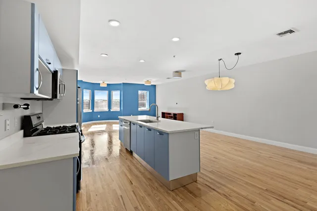 a kitchen with stainless steel appliances granite countertop a sink stove and wooden floor