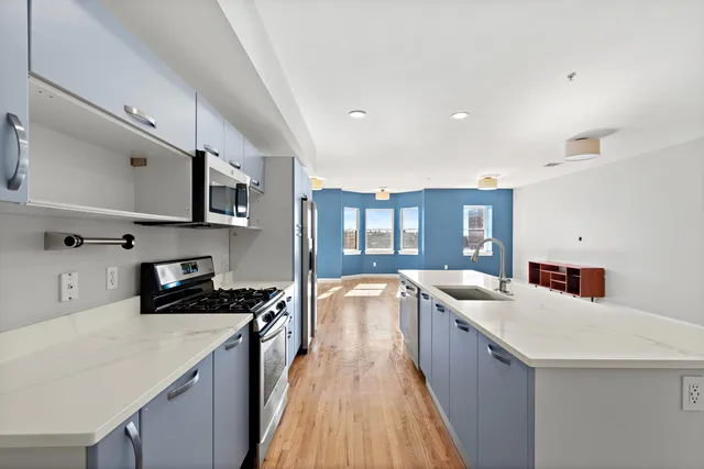 a kitchen with stainless steel appliances a sink stove and cabinets