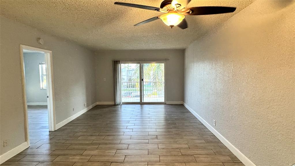 770 Southeast 2nd Avenue, Unit A207 Deerfield Beach, FL 33441 - Photo 3 of 27 an empty room with wooden floor fan and windows