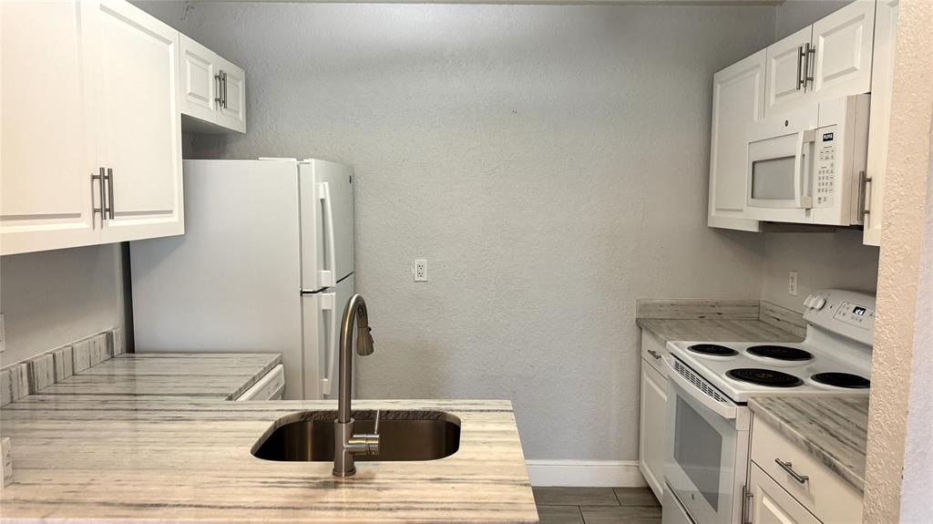 770 Southeast 2nd Avenue, Unit A207 Deerfield Beach, FL 33441 - Photo 5 of 27 a kitchen with stainless steel appliances a sink a stove and refrigerator