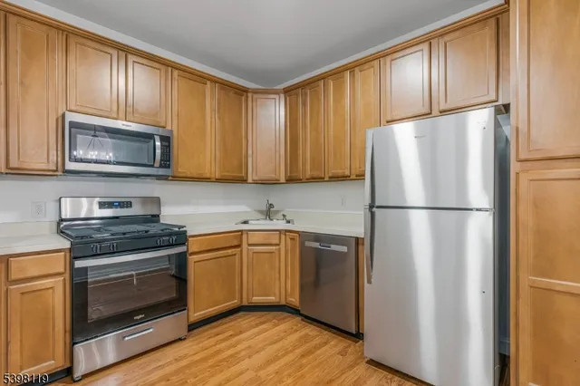 a kitchen with granite countertop wooden cabinets stainless steel appliances and a window